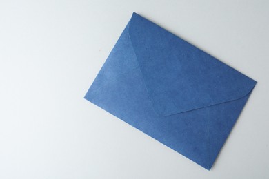 Photo of Blue paper envelope on light background, top view