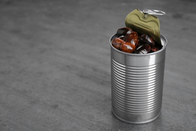 Photo of Tin can with kidney beans on gray table, space for text