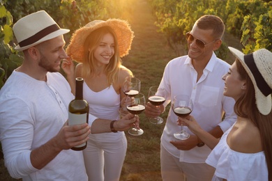 Photo of Friends tasting red wine in vineyard on sunny day