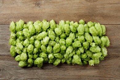 Photo of Fresh green hops on wooden table, flat lay