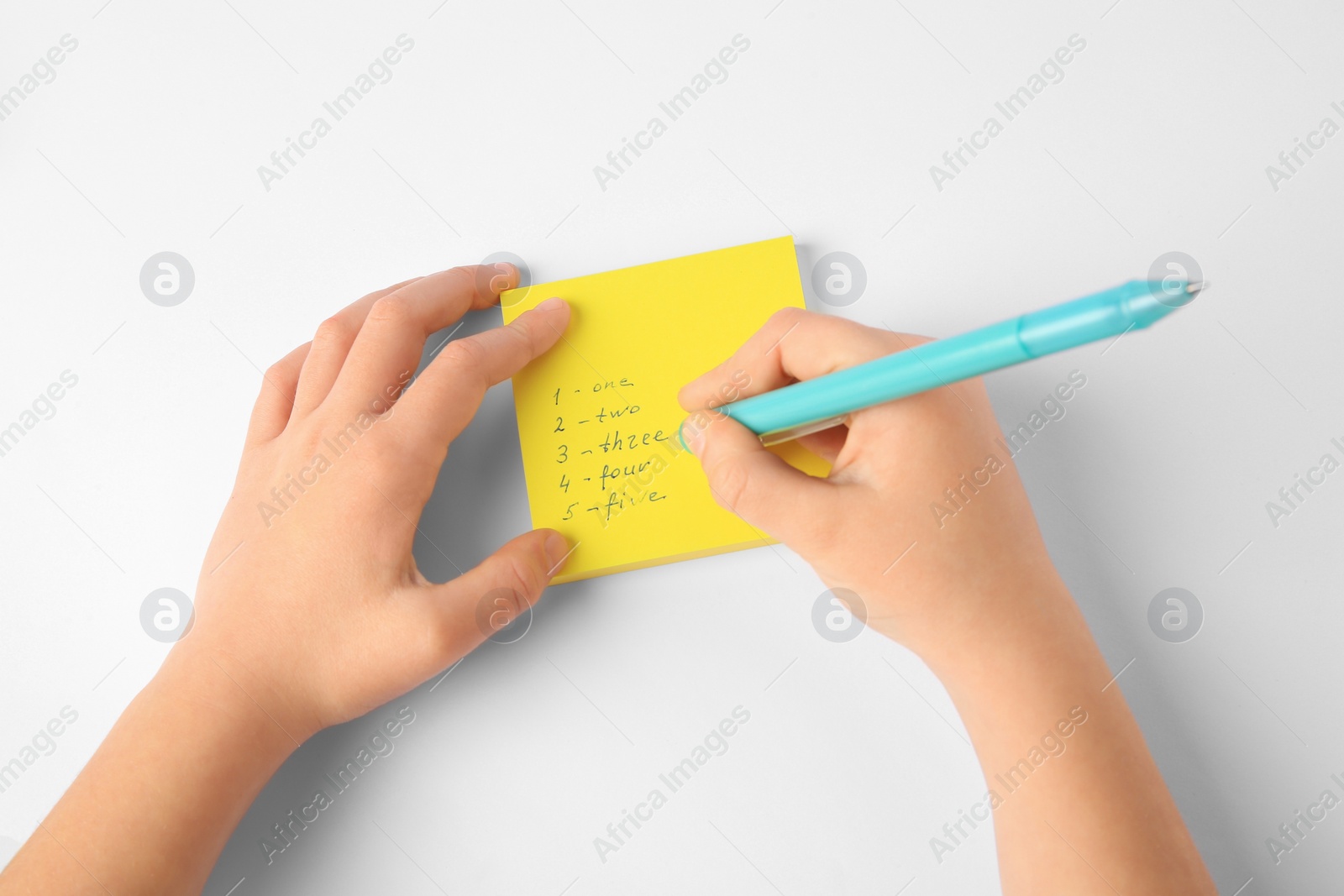 Photo of Child erasing words and numbers written with erasable pen on white background, top view