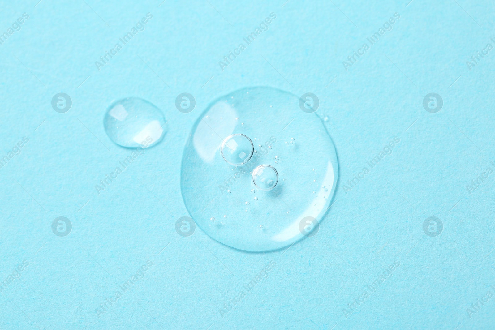 Photo of Samples of cosmetic serum on light blue background, top view