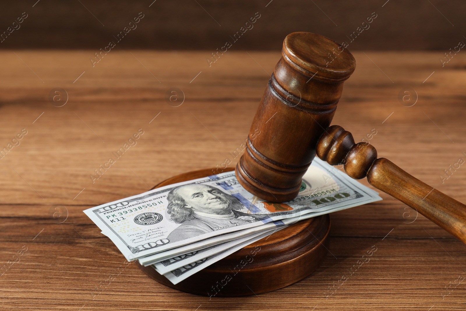 Photo of Judge's gavel and money on wooden table