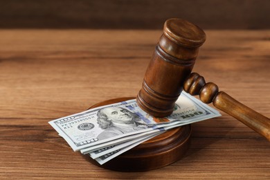 Judge's gavel and money on wooden table