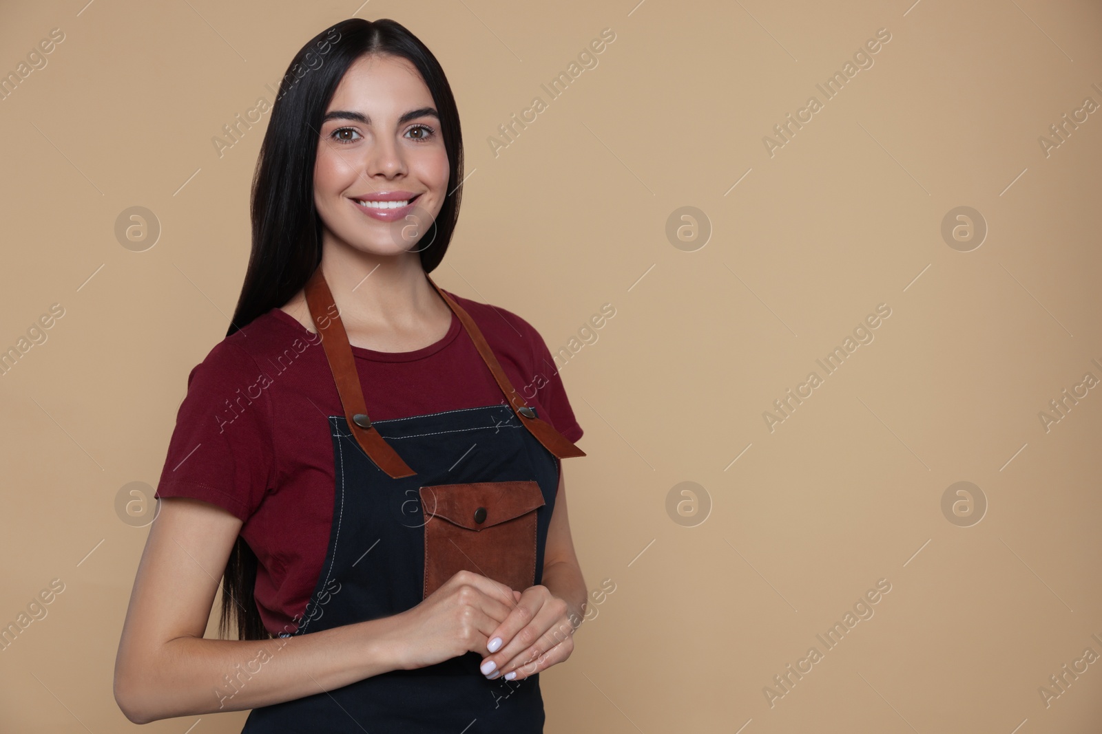 Photo of Portrait of happy hairdresser on beige background, space for text