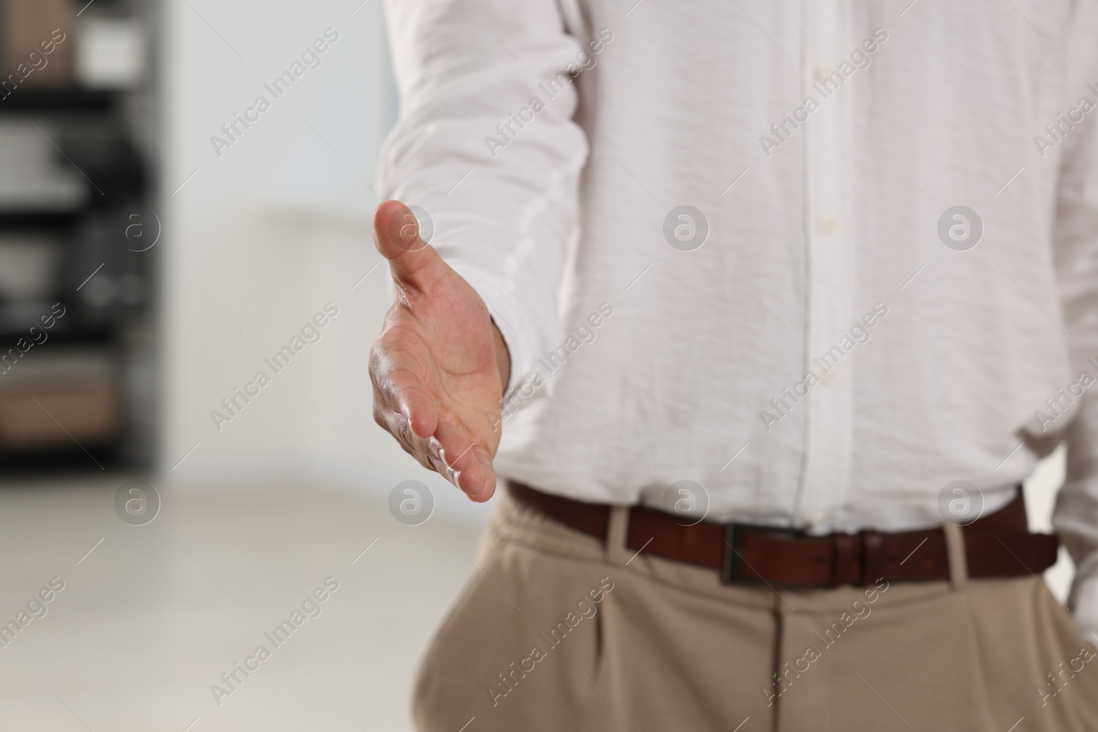 Photo of Man welcoming and offering handshake indoors, closeup. Space for text