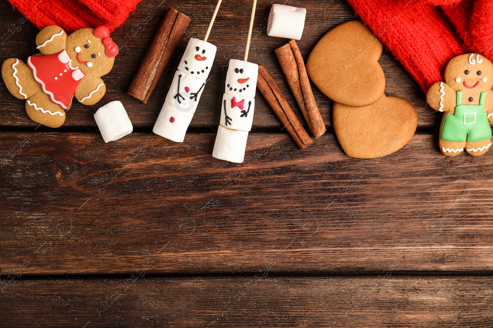 Photo of Flat lay composition with funny snowmen made of marshmallows on wooden table, space for text