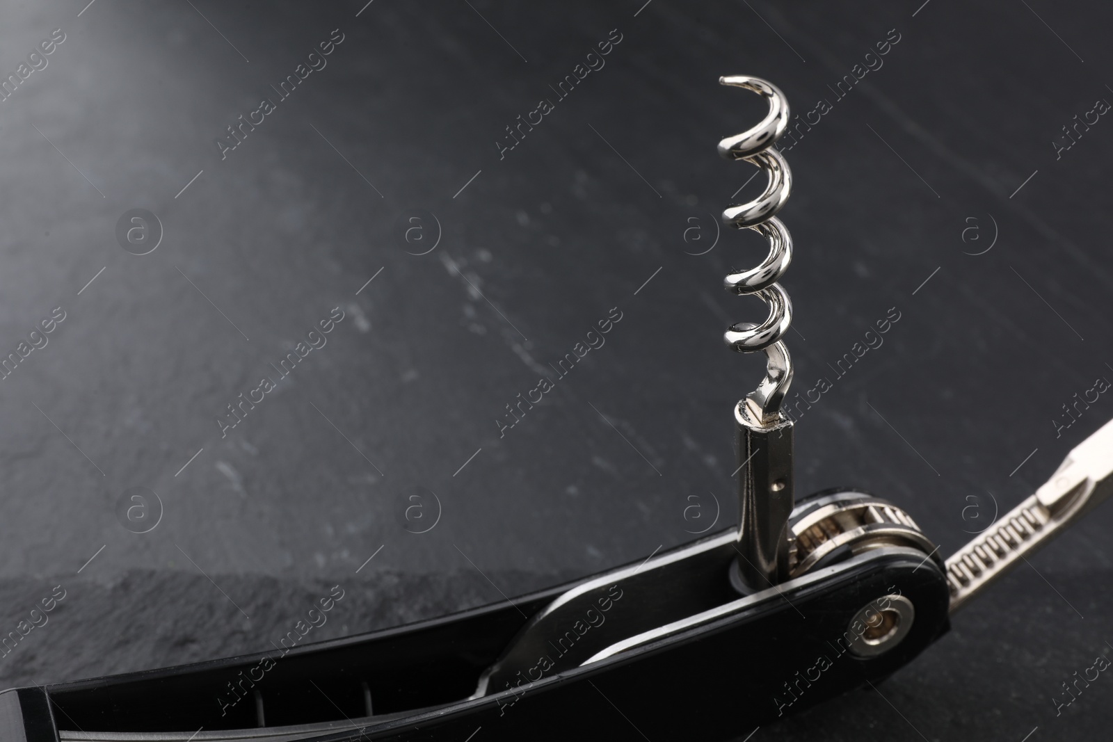 Photo of One corkscrew (sommelier knife) on grey textured table, closeup