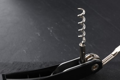 One corkscrew (sommelier knife) on grey textured table, closeup