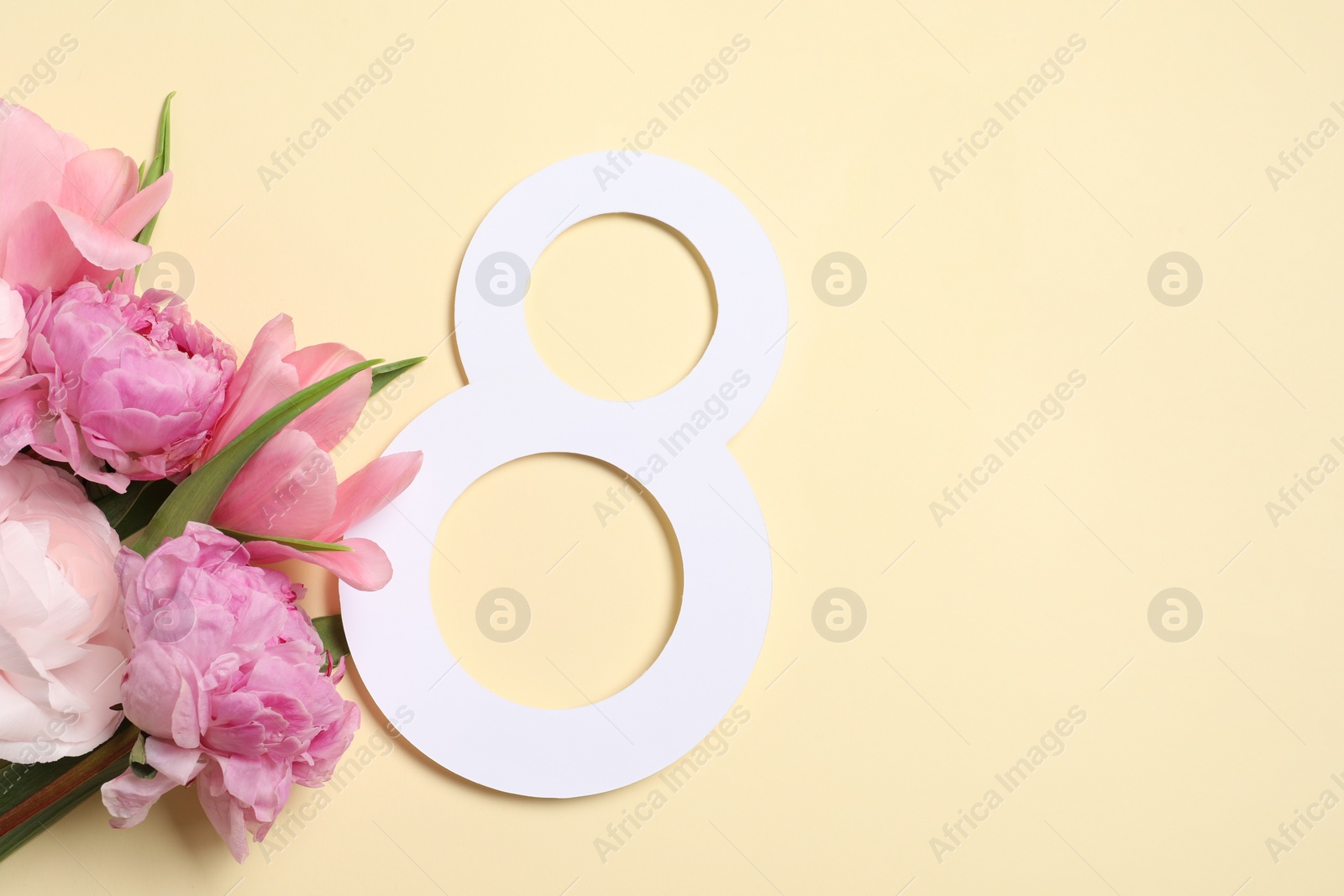 Photo of 8 March greeting card design with beautiful flowers on light yellow background, top view. Space for text