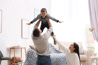 Photo of Happy family with little son having fun at home. Winter vacation