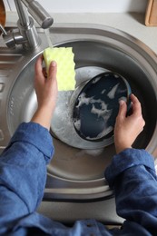 Photo of Woman washing plate in kitchen sink, above view