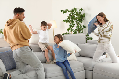 Happy family having pillow fight in living room