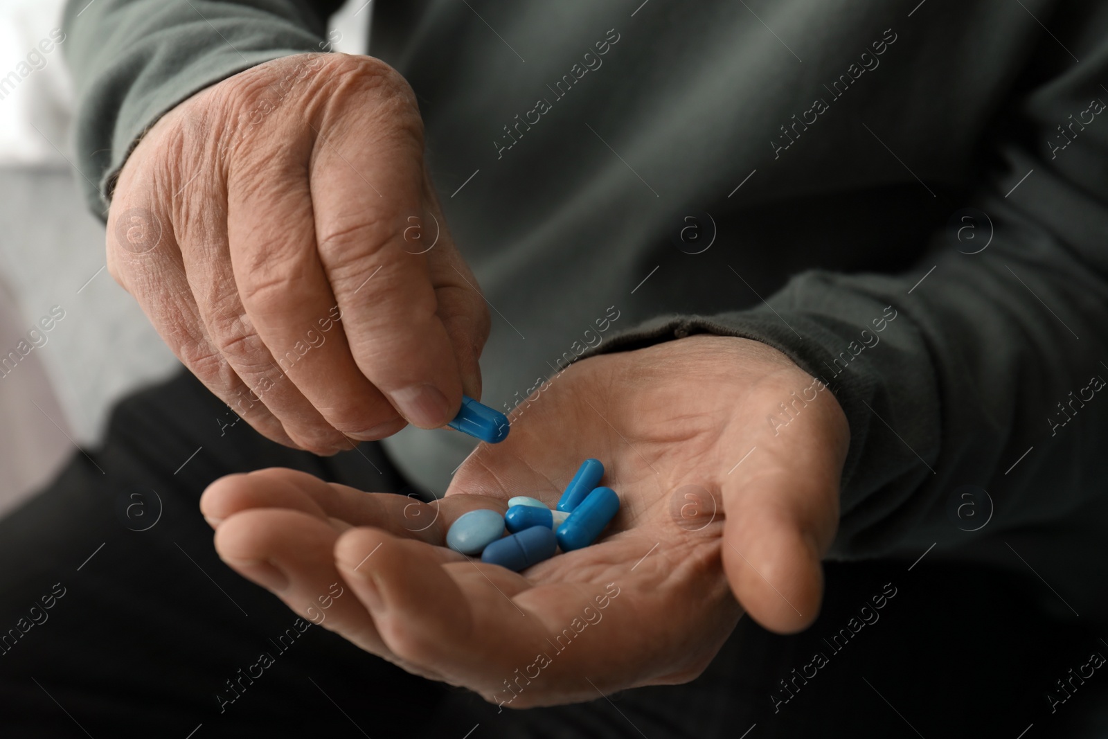 Photo of Senior man taking pills, closeup of hands