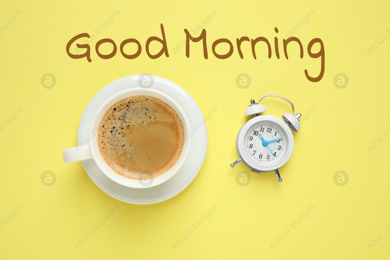 Image of Cup of aromatic coffee and alarm clock on yellow background, flat lay. Good morning