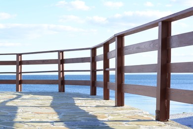 Photo of Wooden railing near sea outdoors on sunny day