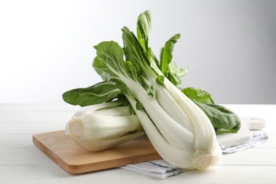 Photo of Fresh green pak choy cabbages on white wooden table