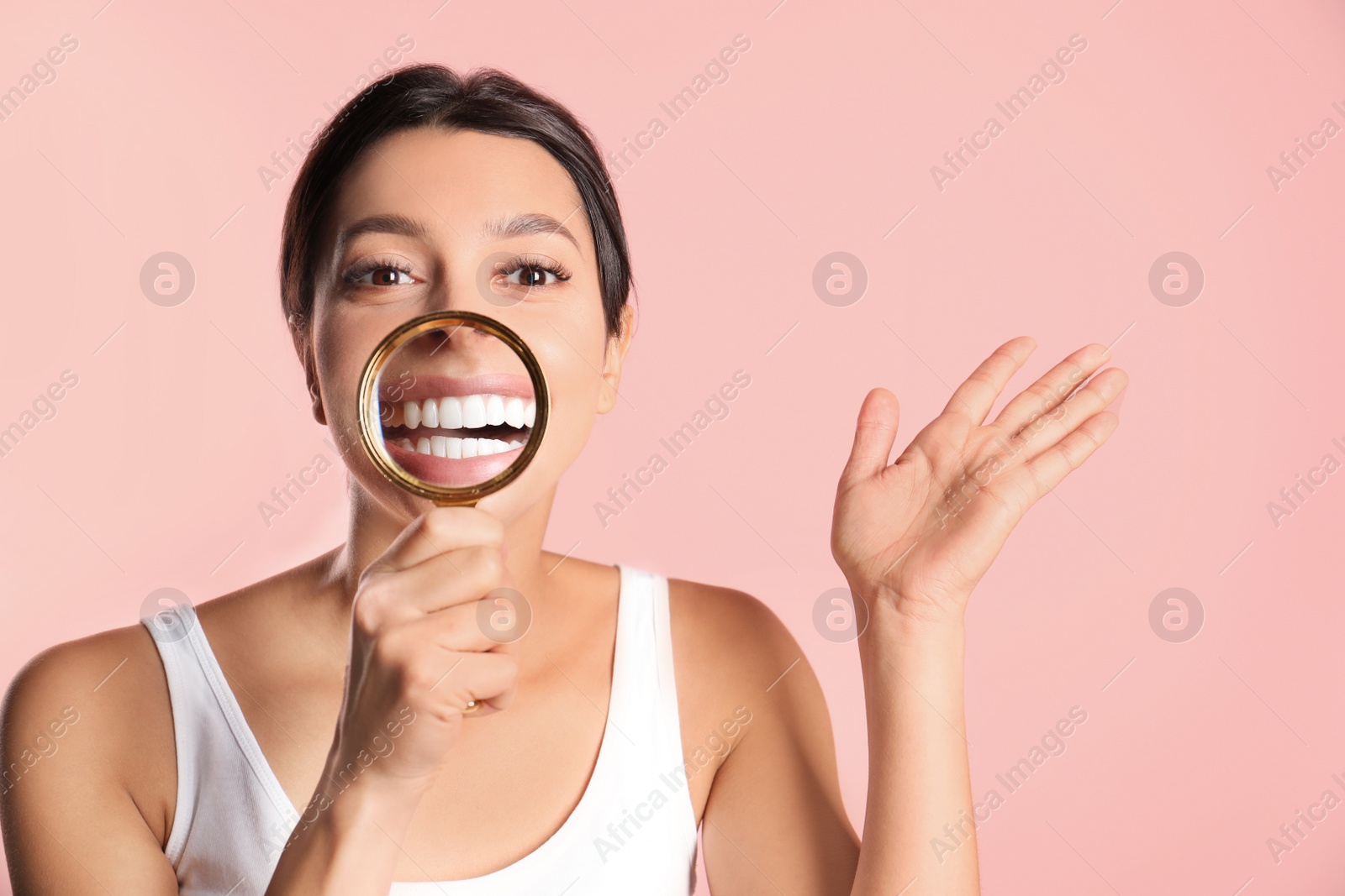 Photo of Young woman with healthy teeth and magnifier on color background