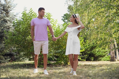 Lovely couple walking together in park on sunny day