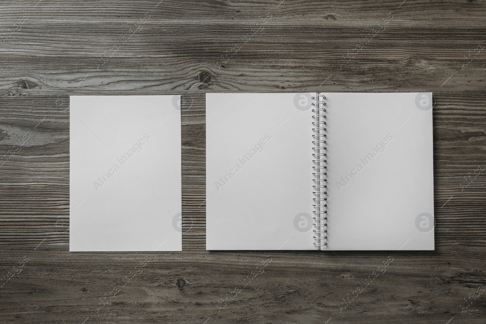 Photo of Sheet of paper and blank brochure on wooden table, flat lay. Mockup for design