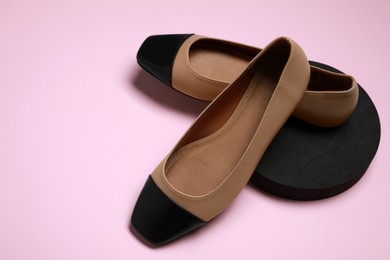 Photo of Pair of new stylish square toe ballet flats on pale pink background. Space for text