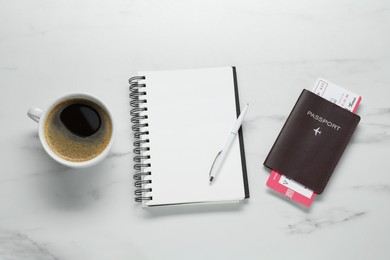 Photo of Flat lay composition with passport, notebook and cup of coffee on white marble table, space for text. Business trip