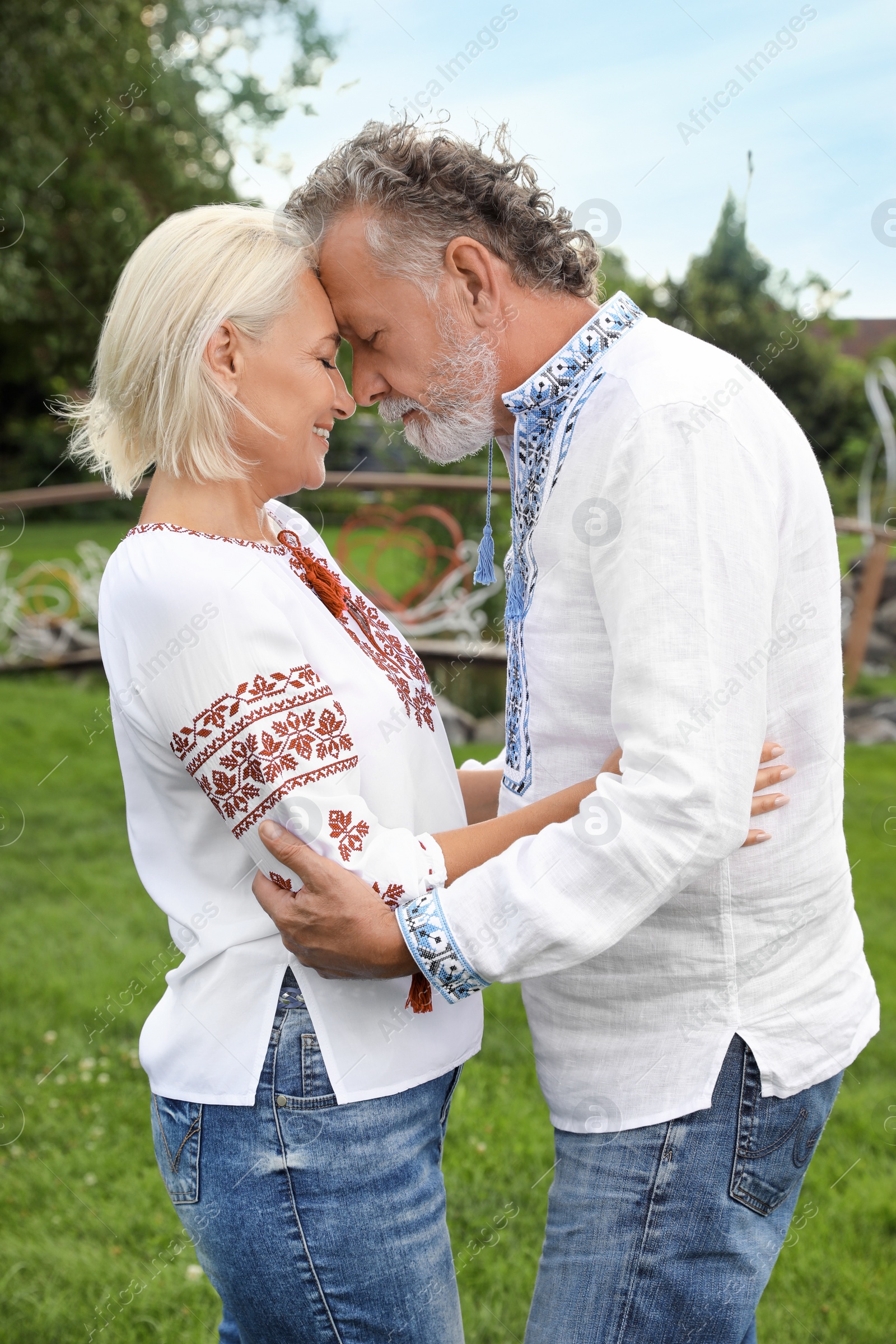 Photo of Happy mature couple in Ukrainian national clothes outdoors