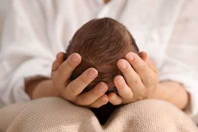 Mother holding her newborn baby, closeup view