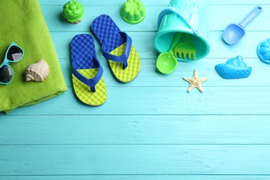 Flat lay composition with bright beach toys on color wooden background. Space for text