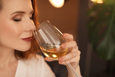 Photo of Woman with glass of delicious wine indoors