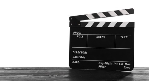 Photo of Movie clapper on wooden table against white background, space for text