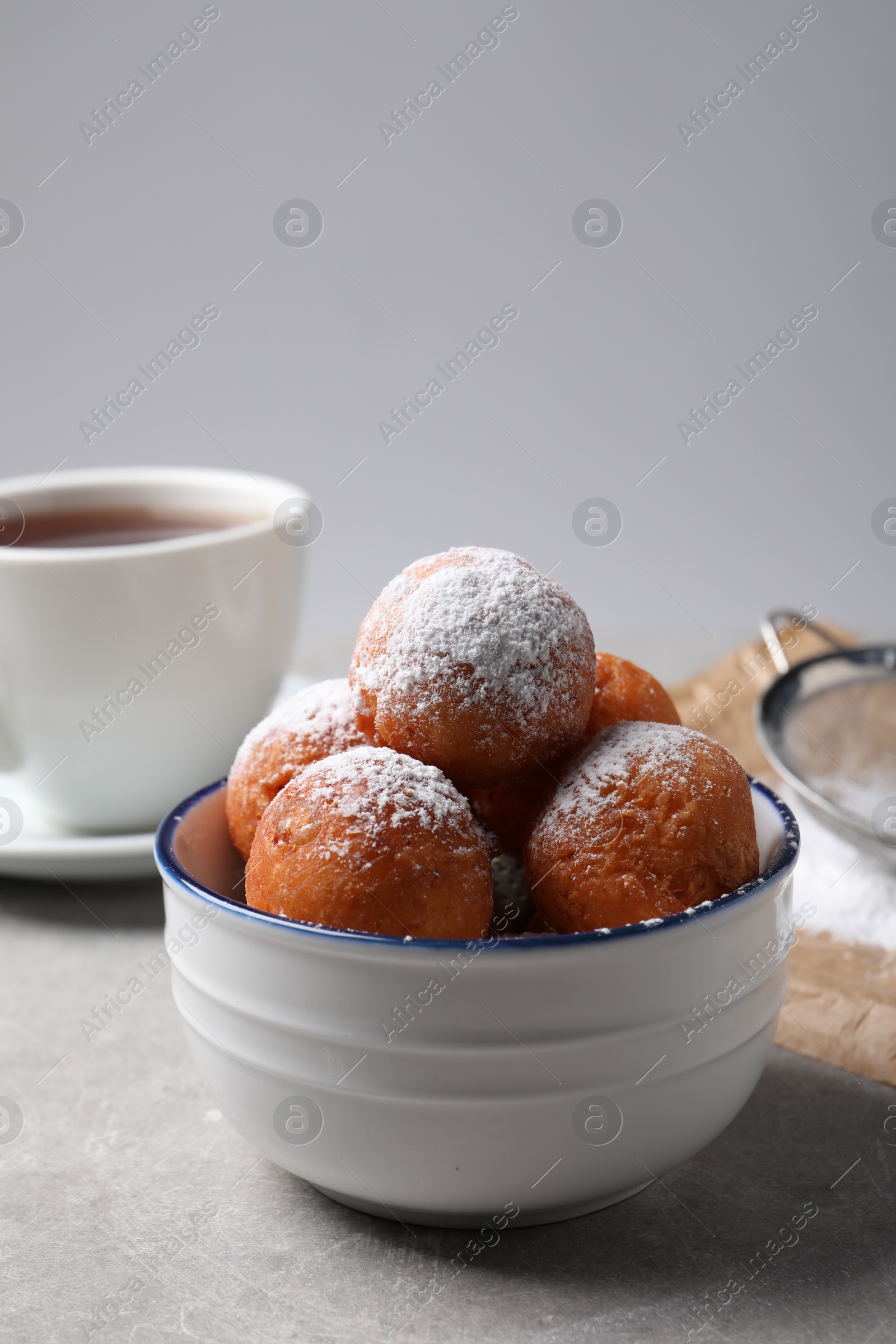 Photo of Delicious sweet buns in bowl on gray table, space for text