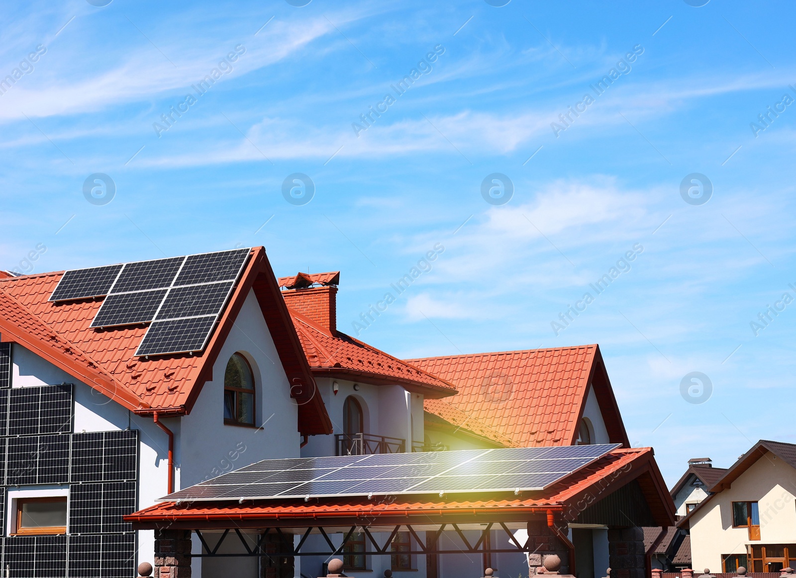 Photo of House with installed solar panels under blue sky. Alternative energy source