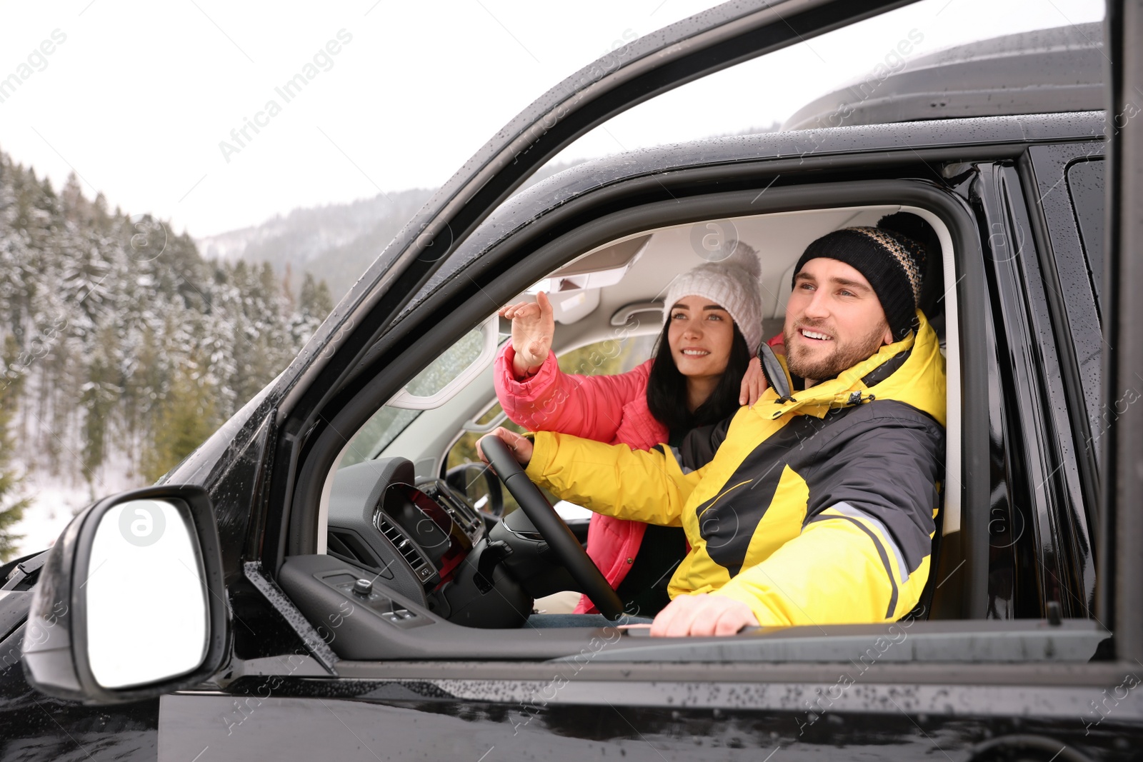 Photo of Happy couple in car outdoors. Winter vacation