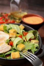 Delicious salad with croutons, chicken and vegetables served on table, closeup