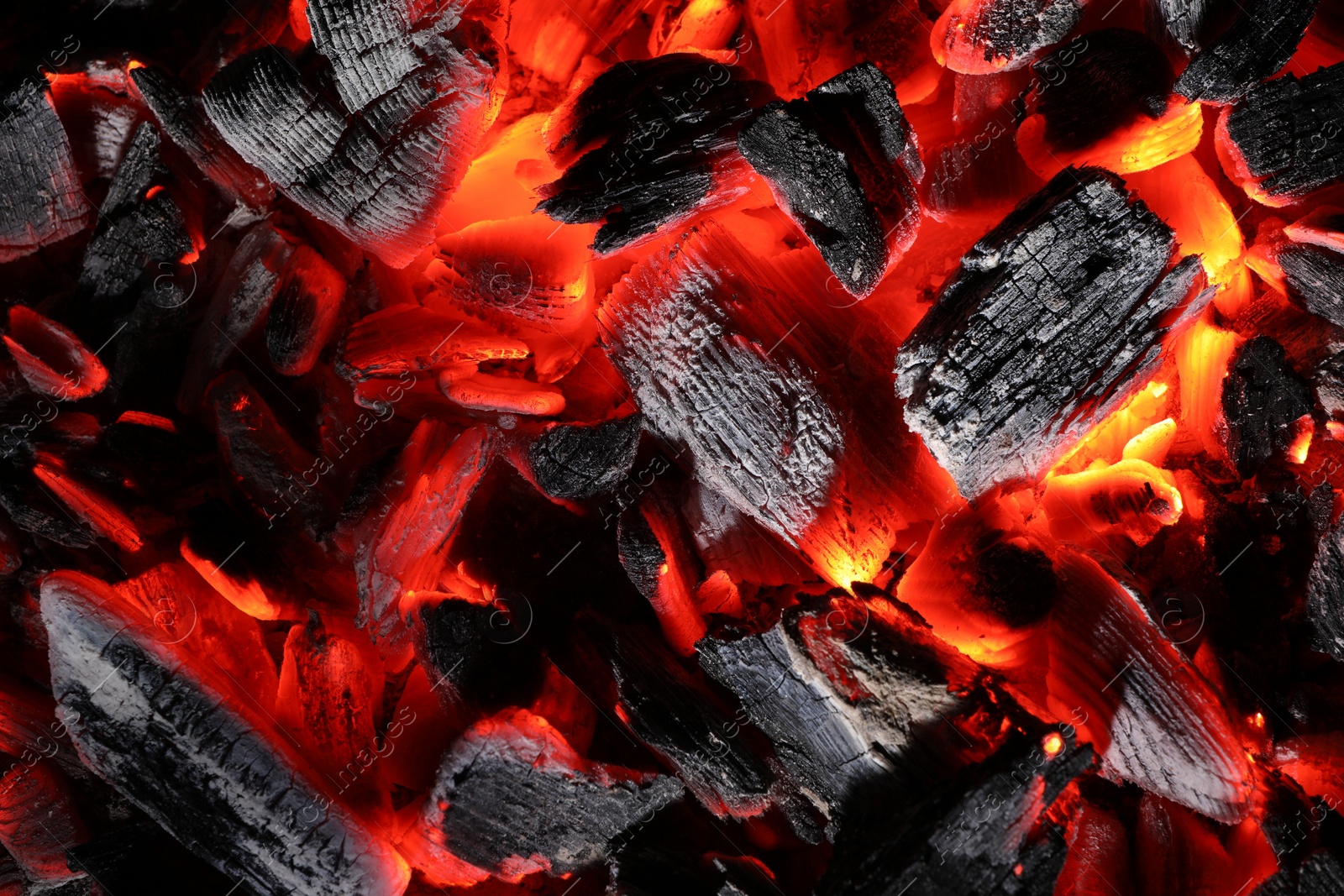 Photo of Pieces of hot smoldering coal as background, top view