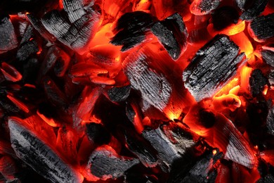 Pieces of hot smoldering coal as background, top view