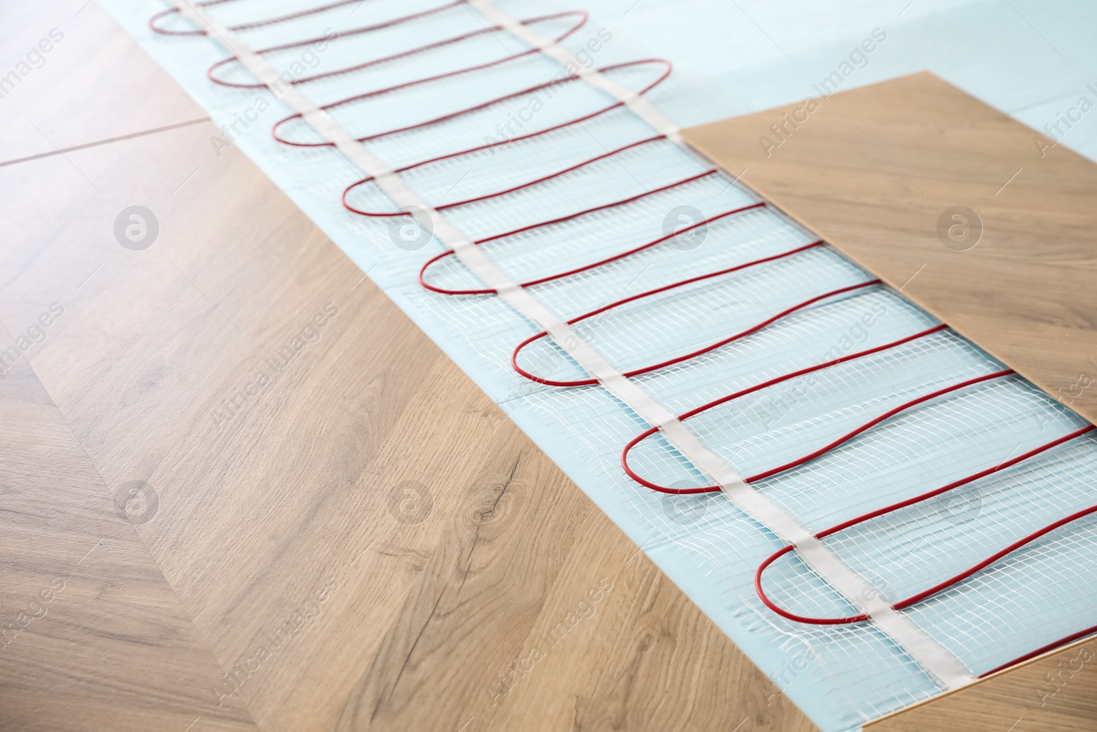 Photo of Installation of modern underfloor trace heating system indoors