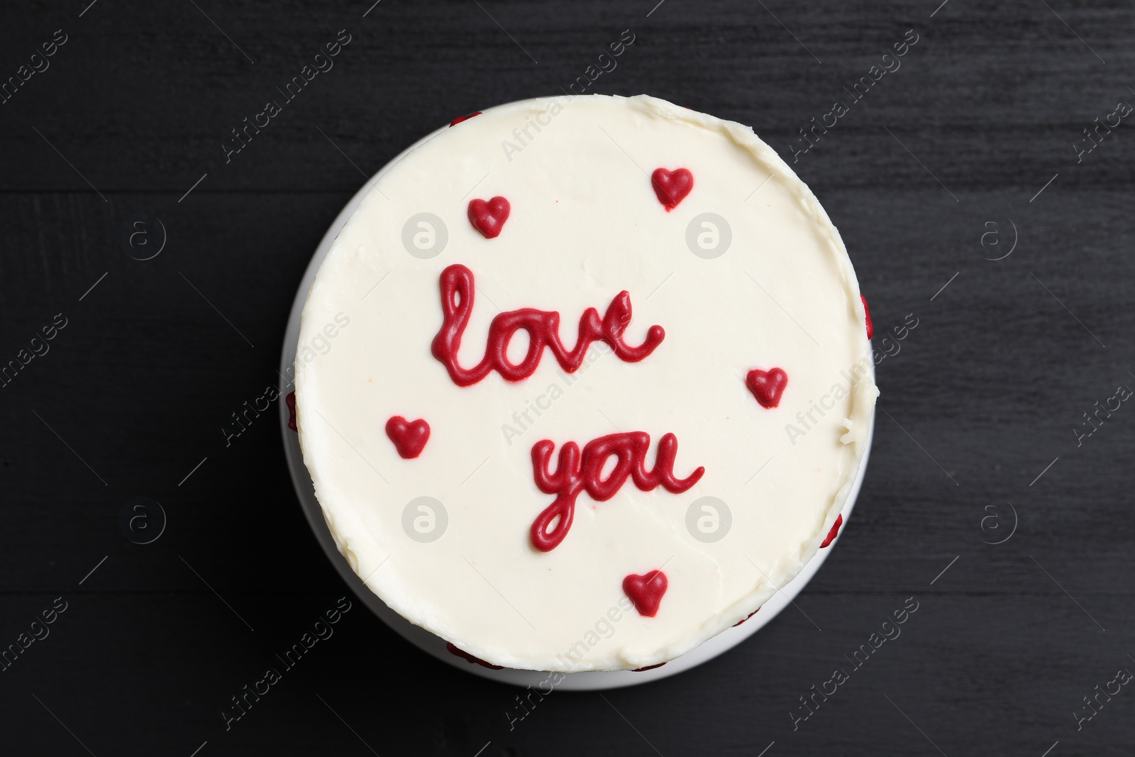 Photo of Bento cake with text Love You on black wooden table, top view. St. Valentine's day surprise