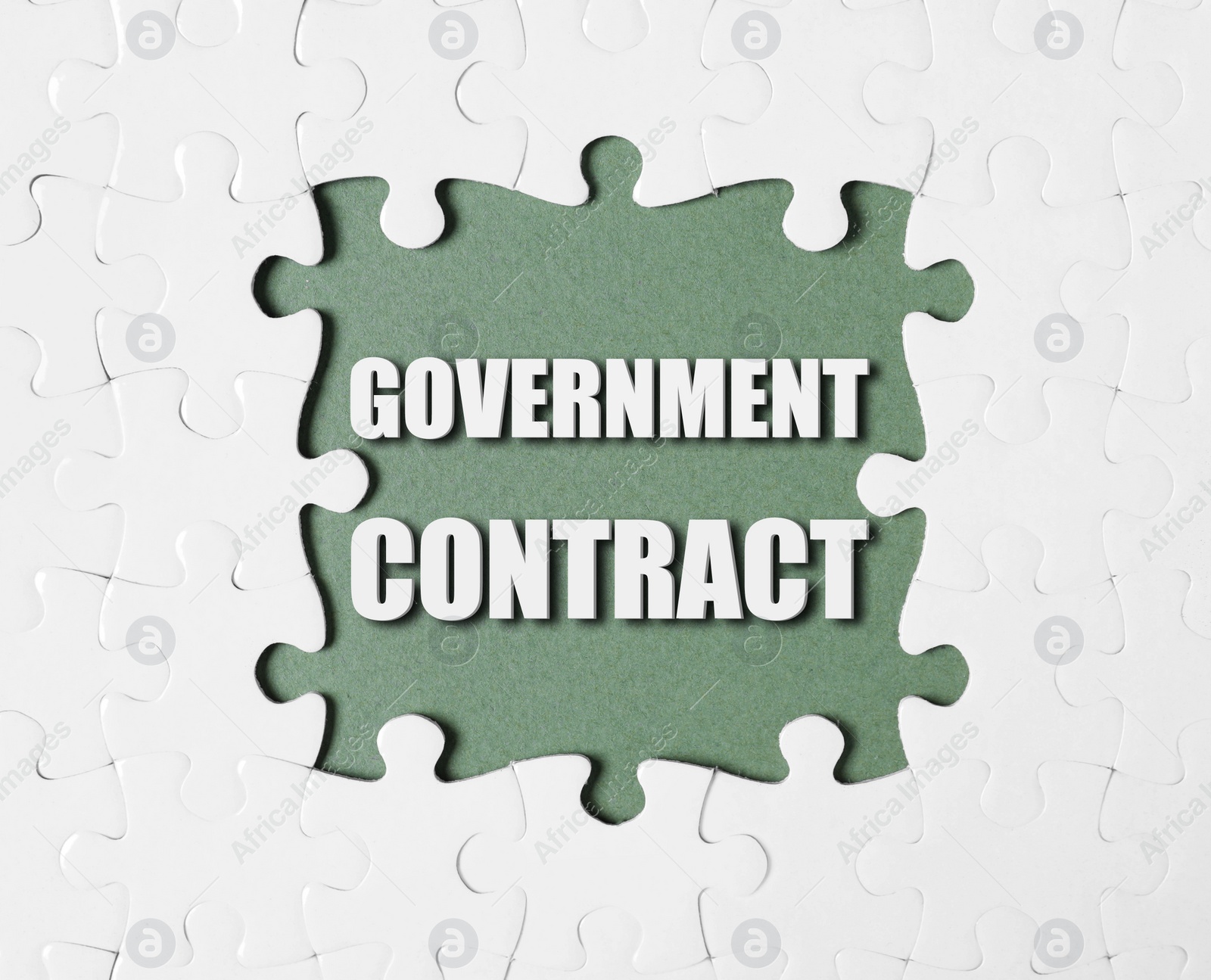 Image of Words Government Contract surrounded by white puzzle pieces on olive color background, top view