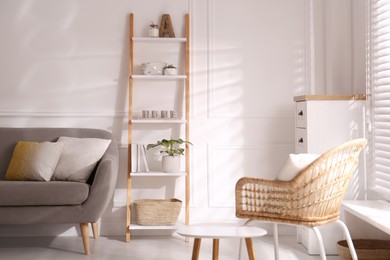 Photo of Elegant decorative ladder near sofa in living room