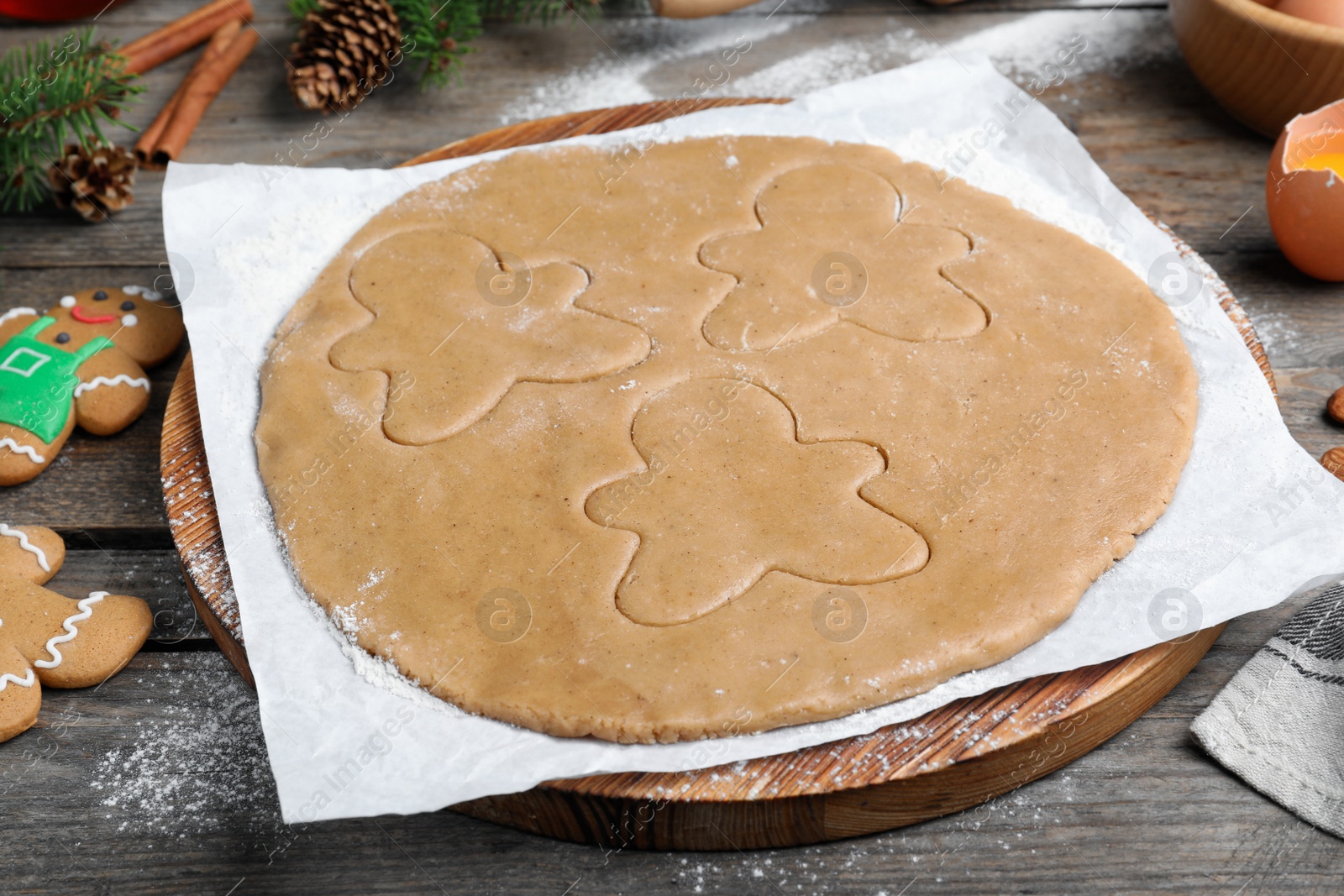 Photo of Making homemade Christmas cookies. Dough for gingerbread man on wooden table