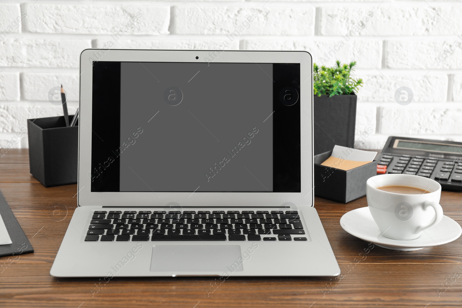 Photo of Modern laptop with blank screen on table. Space for design