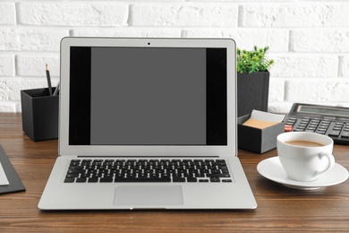 Photo of Modern laptop with blank screen on table. Space for design