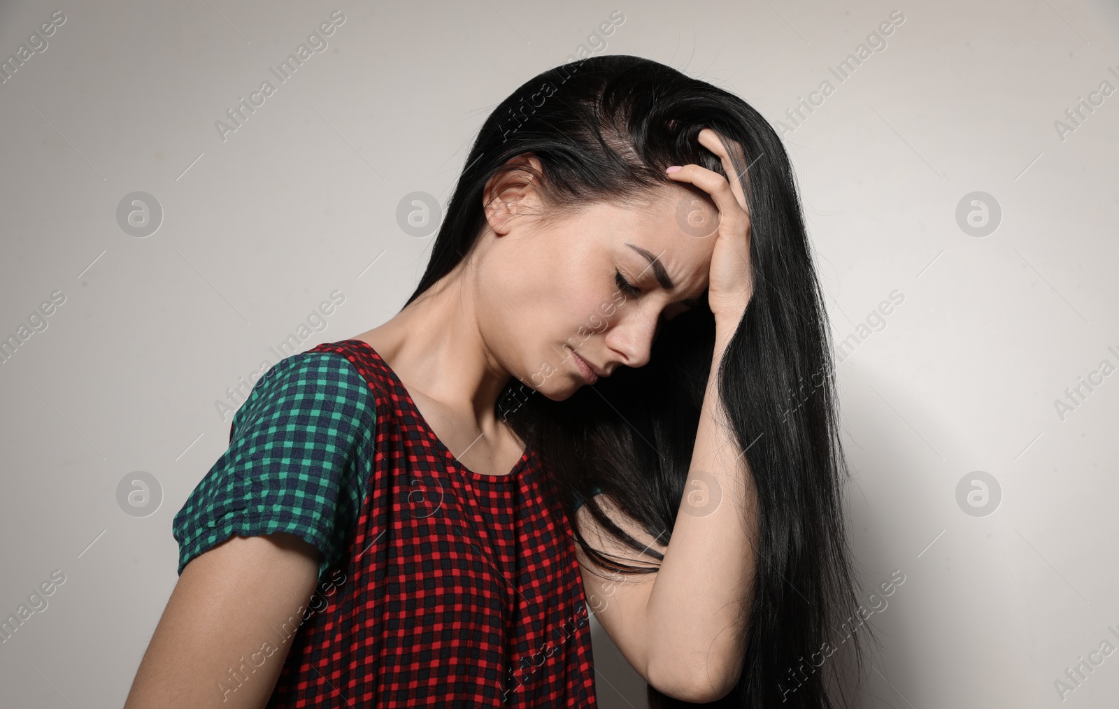 Photo of Portrait of upset young woman on light background