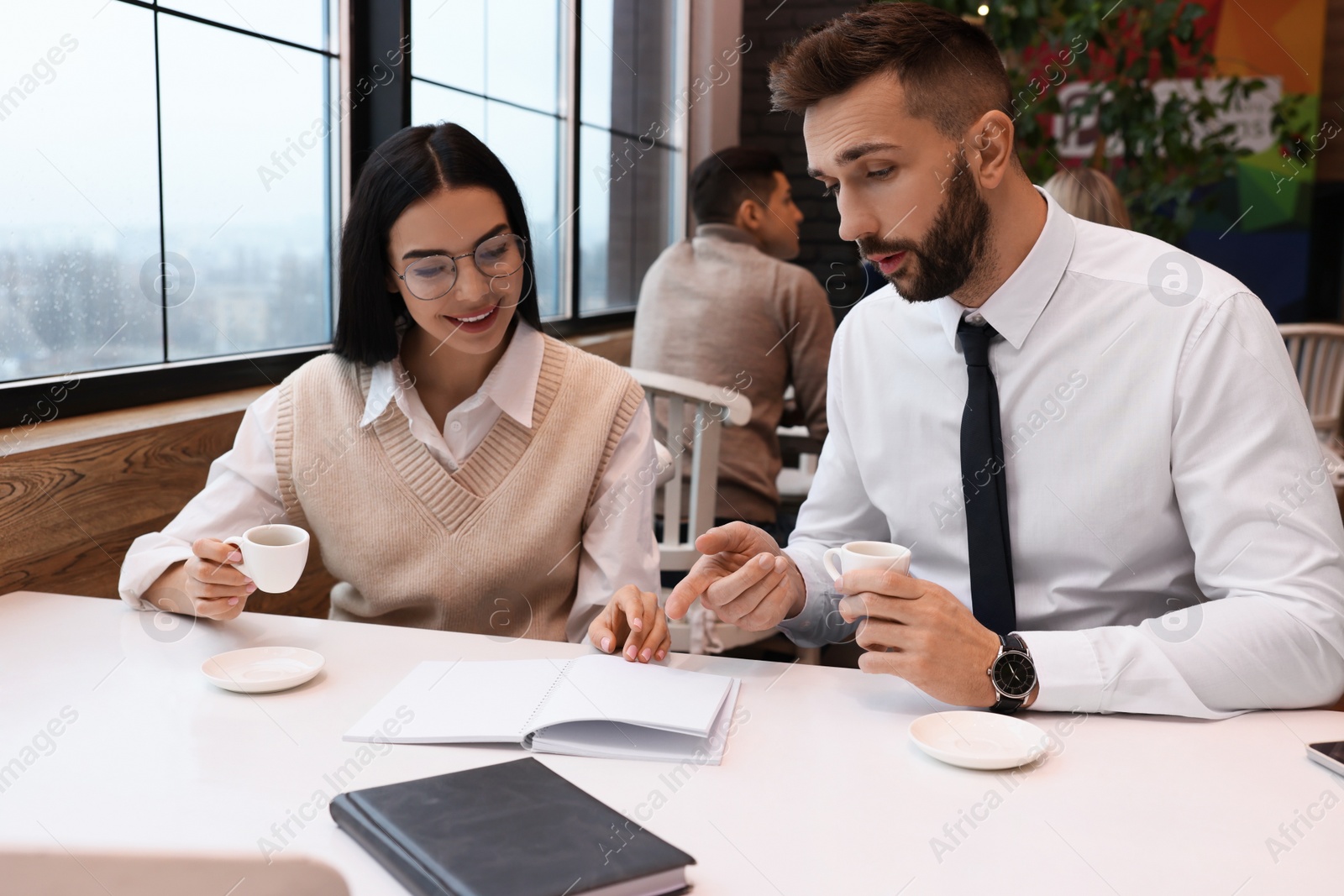 Photo of Coworkers talking in cafe during coffee break