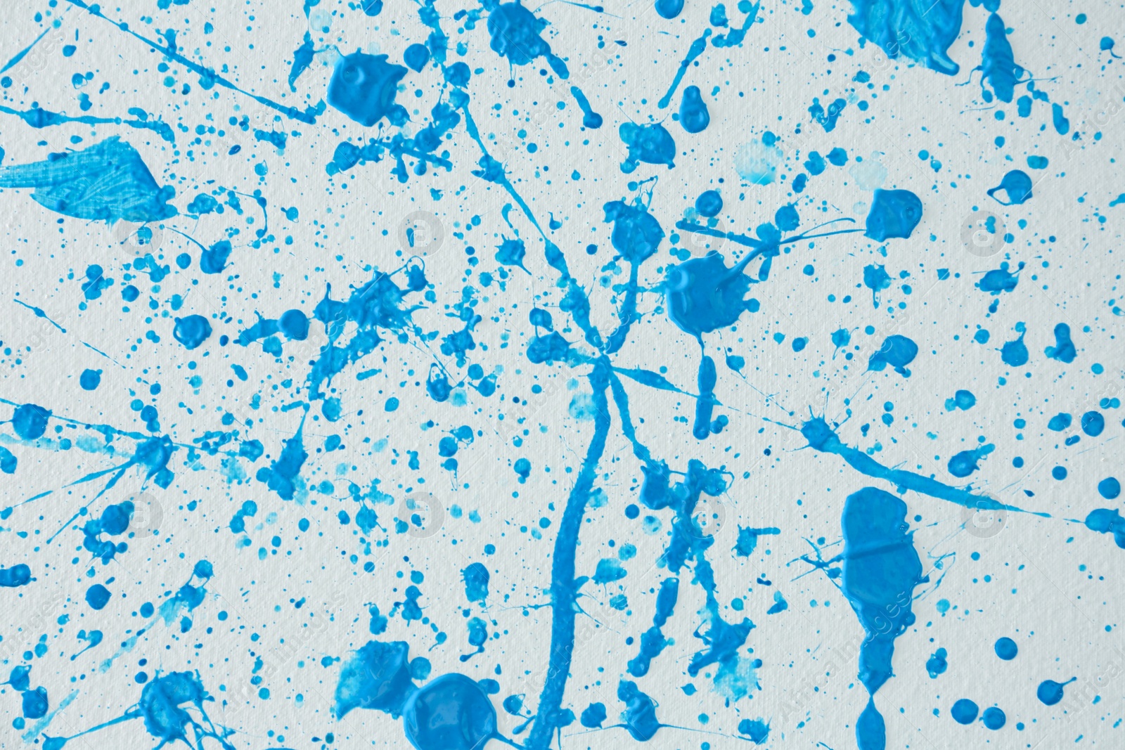 Photo of Blue paint splashes on white canvas as background. Art and creativity