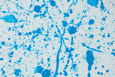 Photo of Blue paint splashes on white canvas as background. Art and creativity