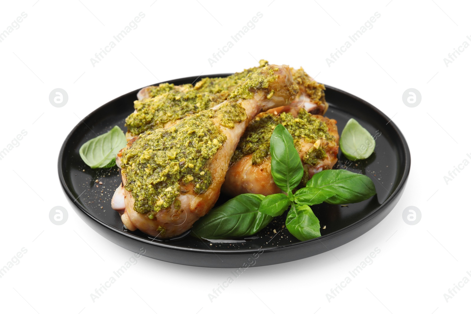 Photo of Delicious fried chicken drumsticks with pesto sauce and basil isolated on white