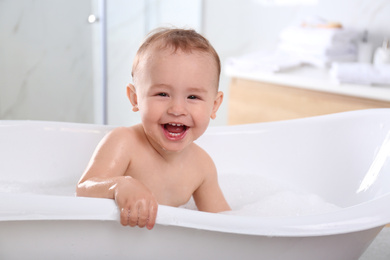 Cute little baby in bathtub at home